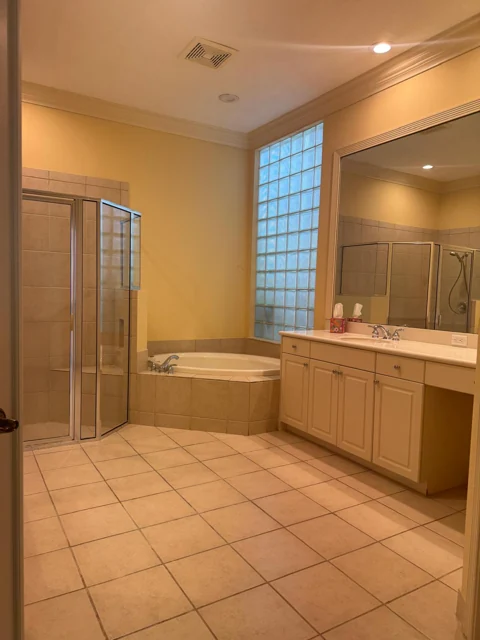Bathroom with a double vanity, tiled floor, bathtub, and glass shower enclosure